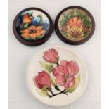 A Moorcroft Magnolia plate diameter 26cm; 2 Moorcroft plates decorated with flower heads diameter