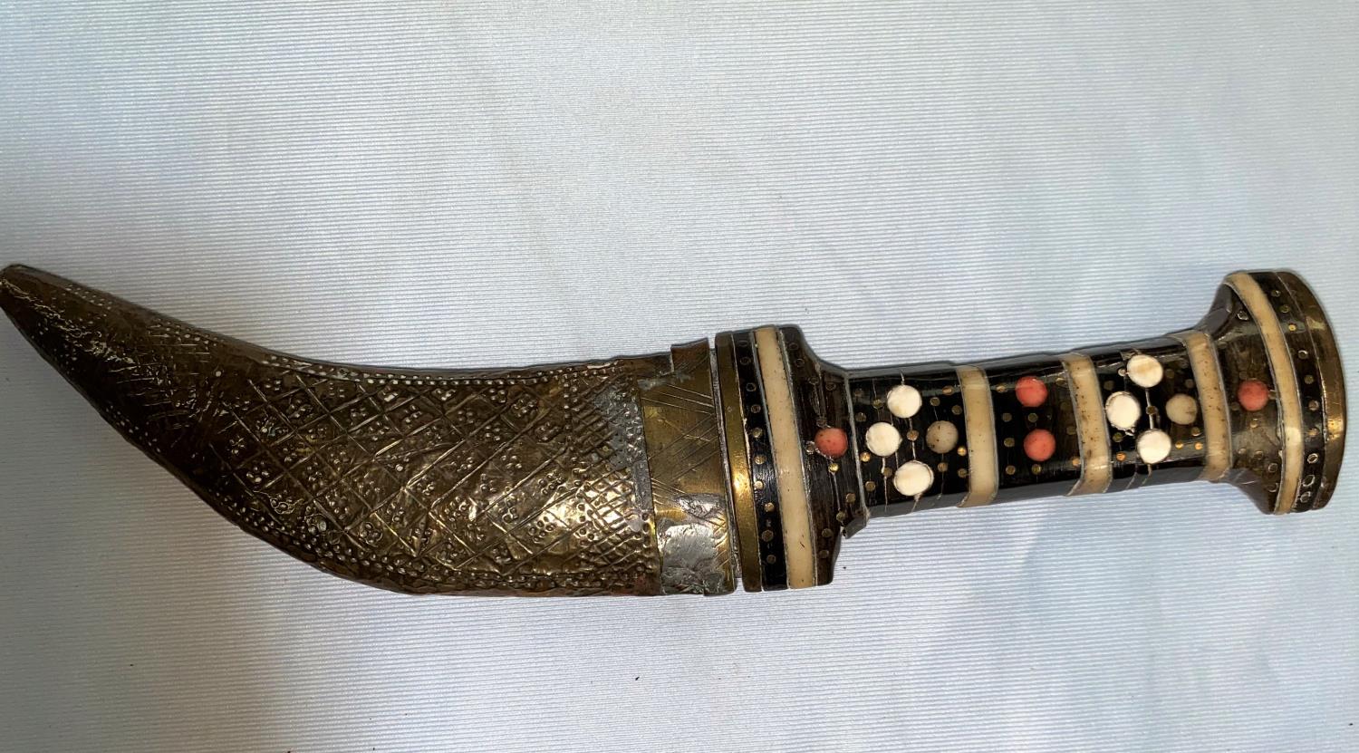 A vintage Middle Eastern dagger with inlaid hilt, embossed brass scabbard & Arabic script to the
