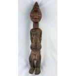 An African tribal carved wood figure of a man, shallow carved geometric decoration, applied fabric