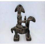 An East African tribal carved wood figure of a man on horseback, applied black stain finish,