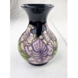 A bulbous Moorcroft vase with flared rim decorated with lilac coloured flowers & green leaves
