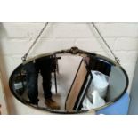 A silvered framed oval mirror