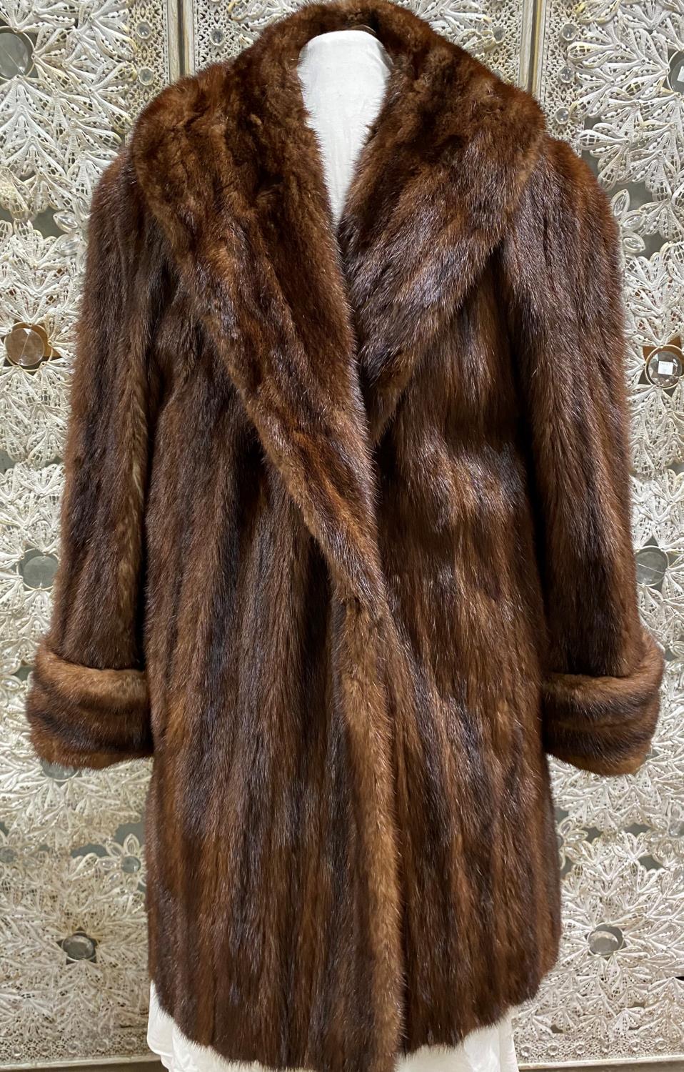 A vintage three quarter length brown A line mink coat with turn back cuffs