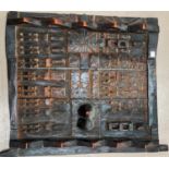 An African tribal carved and patinated wood grain store door, multiple carved figures, flanked by