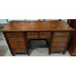 An Edwardian mahogany kneehole desk with 4 small frieze drawers & 8 pedestal drawers, with brass