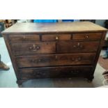 An antique stained pine chest of 7 graduating drawers, on ogee bracket feet, 133 cm (split to top