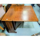 A 1930's square end, golden oak drop-leaf dining table.