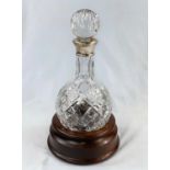 A cut glass decanter by Mappin & Webb with silver collar and rounded bottom, inscribed, original box