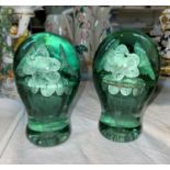 A Victorian pair of green glass dumpies with internal flowers, height 14 cm (1 split across and