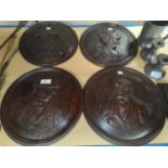 A carved oak set of 4 roundels depicting Dickens characters