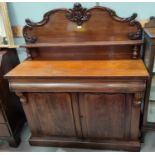 A Victorian figured mahogany chiffonier with carved arched back and raised shelf over frieze
