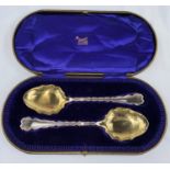 A hallmarked silver pair of serving spoons with wavy borders and gilded bowls, for Beavers of