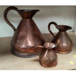 A 19th century matched set of three graduating copper measuring jugs, the smaller of the three