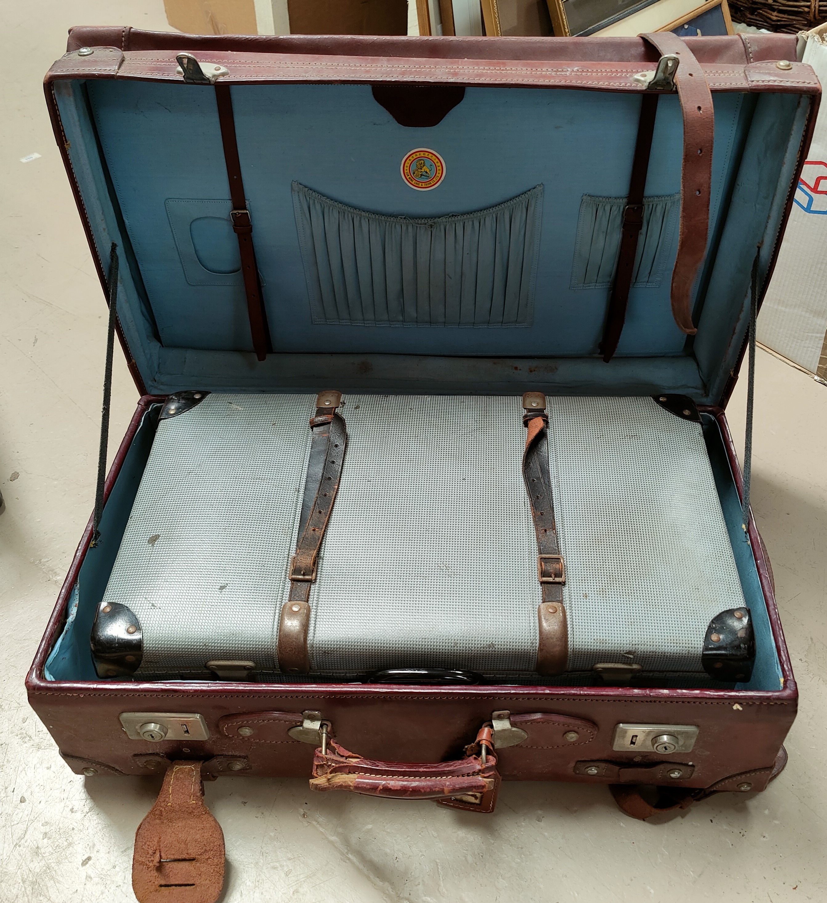 A large strapped leather suitcase; a compressed card suitcase