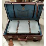 A large strapped leather suitcase; a compressed card suitcase