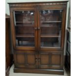 An Ercol dark oak display cabinet with 2 glazed and 2 panelled doors