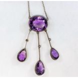 An Arts and Crafts white metal negligee pendant set oval amethyst with three drops each set single