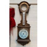 An Edwardian clock/barometer with thermometer in carved oak case, height 96 cm (clock missing)