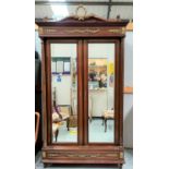 A late 19th/early 20th century Louis XV1 style mahogany wardrobe enclosed by two beveled mirror