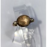 A late Georgian gold dress ring set single oval cut and foiled back stone, with single seed pearl to