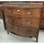 An early 19th century inlaid mahogany bow front chest of 3 drawers with brass drop handles, on