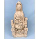 A 19th century Chinese blanc de chine figure of Guanyin and Chi, seated above a dragon with acolyte