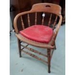 An oak smoker's / captain's stick back bow armchair with red effect leather cushion seat