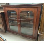 A 1920's mahogany display cabinet enclosed by 2 doors on ball and claw feet (one glass pain cracked)