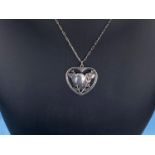 Georg Jensen, a heart shaped silver pendant with inset bird with outstretched wings perched on a