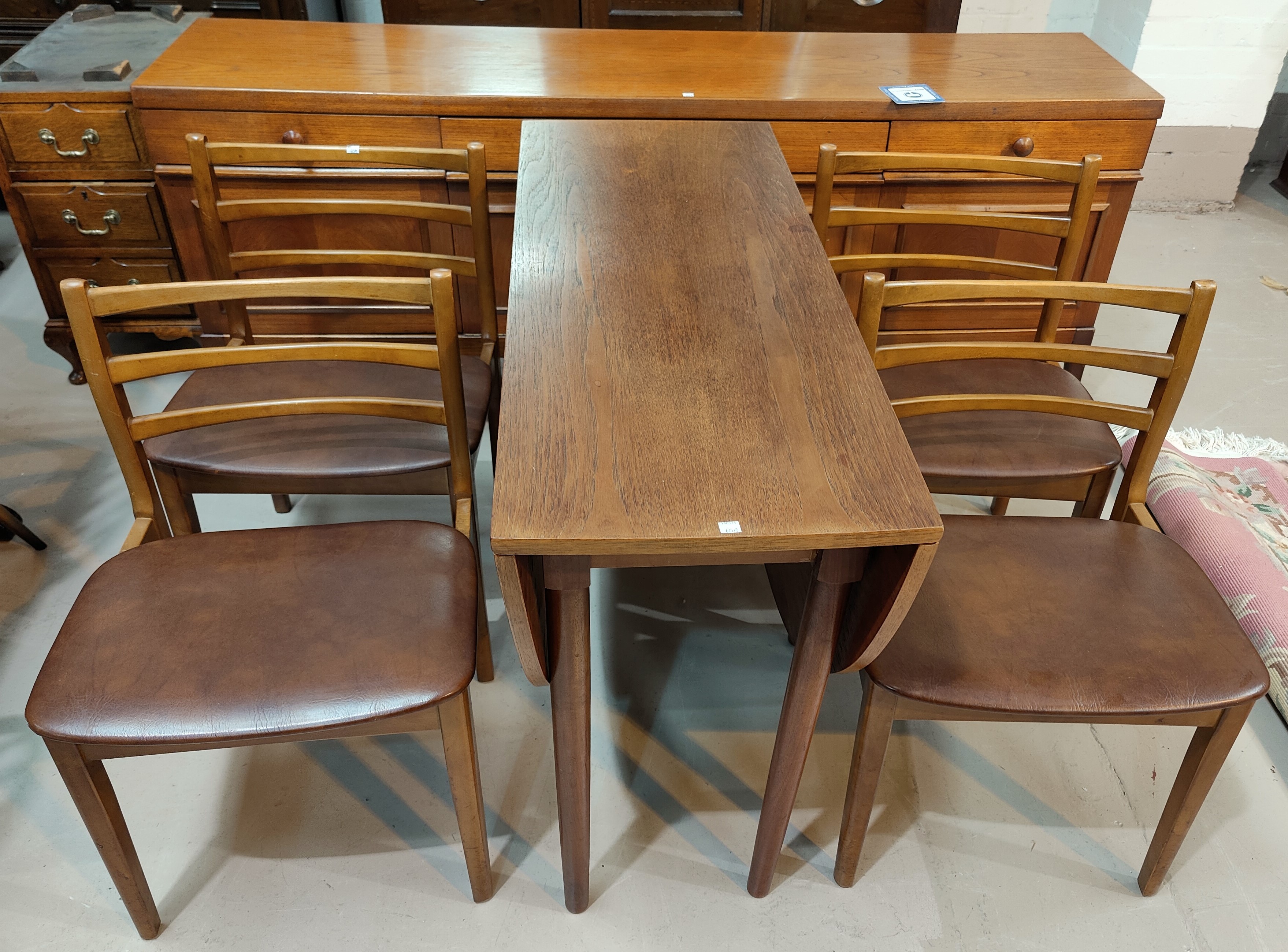 A 1960's teak G-Plan style dining suite, comprising drop leaf table, sideboard and 4 chairs; a