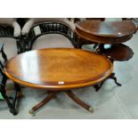 A reproduction mahogany coffee table with oval top on pedestal base; a drum table; an inlaid hall