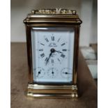 A reproduction brass carriage clock with repeating/striking movement, white enamel dial with 3