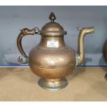 An Indian brass kettle with hinged lid, wide body and serpent headed handle and spat