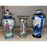 A Chinese covered inverted baluster vase decorated in the famille rose palette with figures in