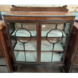 An early 20th century mahogany china display cabinet enclosed by 2 glazed doors, on ball and claw