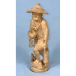 An early 20th century Japanese okimono ivory figure if a a fisherman with cormorant and net, red