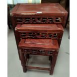 A modern Chinese nest of four stained wood occasional tables
