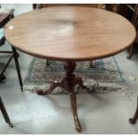 An early 19th century mahogany table with circular tilt top, on turned column and triple splay feet,