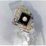 An Art Deco style diamond and black onyx ring in 18ct (stamped) white gold, comprising of a