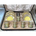 A cased set of 6 Aynsley coffee cups and saucers in pierced hallmarked silver holders, Sheffield