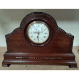 A mantel clock in mahogany arch top case with beaded decoration, white enamel dial and balance