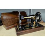 An early 20th century hand operated sewing machine in walnut case