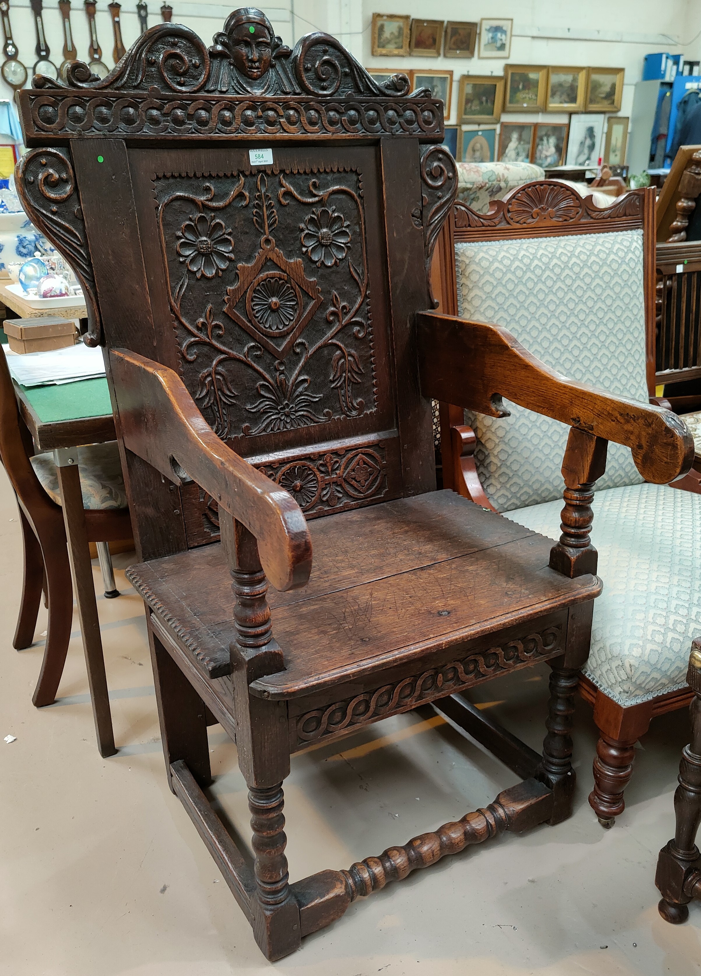 A 17th century style carved oak wainscot chair with solid seat