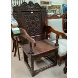 A 17th century style carved oak wainscot chair with solid seat