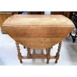 A 1930's oak table with oval dropleaf top on barley twist legs; 3 similar dining chairs