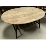 An Ercol oval coffee table with a light wood top and painted legs and under shelf.