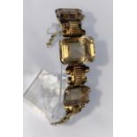 A continental yellow metal bracelet set with 3 rectangular Smokey citrine stones tested 14ct,