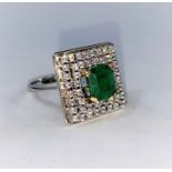 A white metal Art Deco style ring set square emerald surrounded by clear stones, tests as 14 ct, 8.5