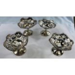 A set of 4 sweetmeat dishes on pedestal bases with pierced and embossed decoration, on weighted