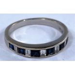 A white metal half eternity ring set alternating square cut sapphires and rectangular cut